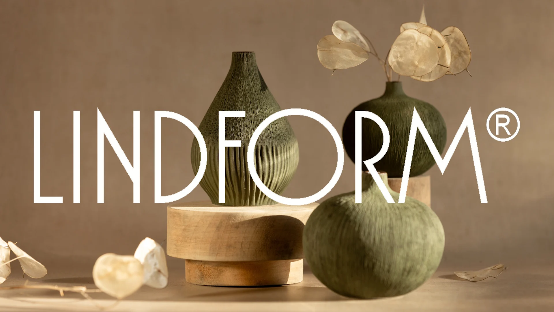 Tre gröna, texturerade vaser på träunderlägg med torkade blommor och "LINDFORM®"-logotyp.