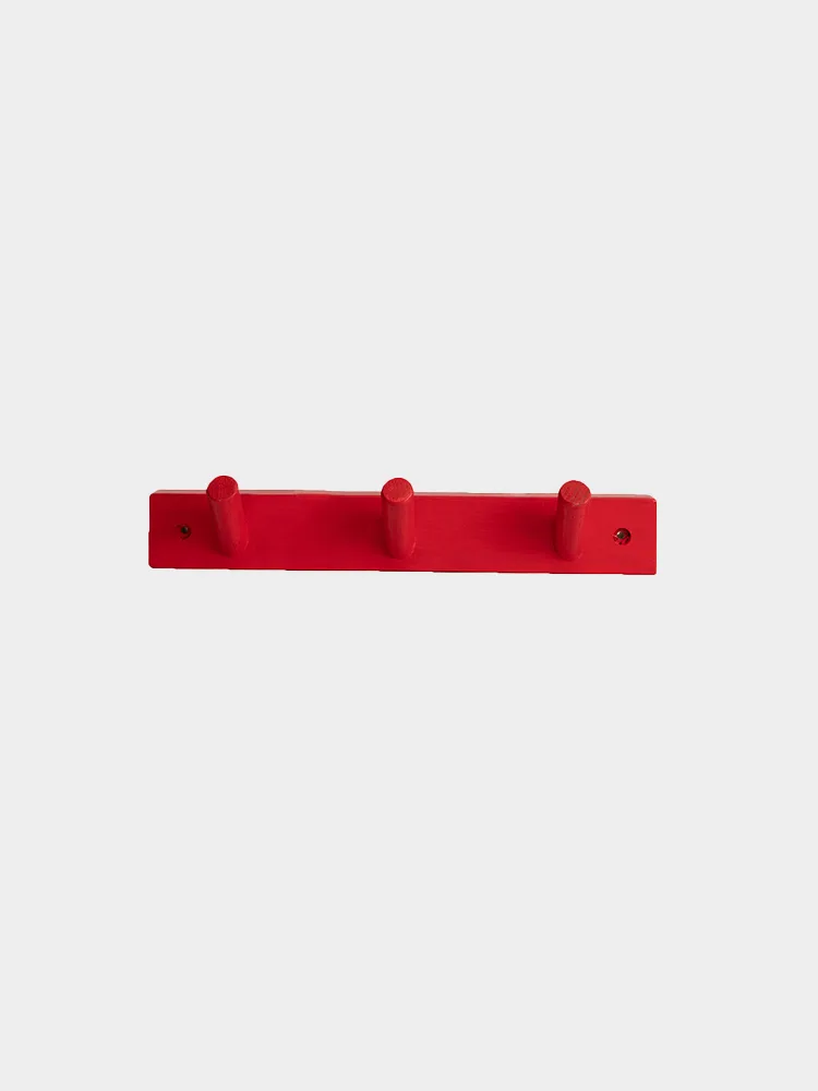 Röd klädhängare med tre krokar.